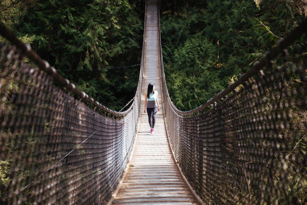 negative space woman walking swing bridge burst thumb 1