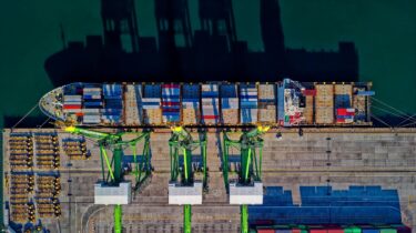 a boat getting loaded with shipping containers