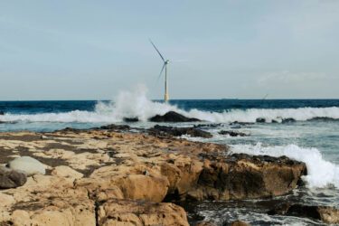 Rocks on Sea Shore with Wind Turbine